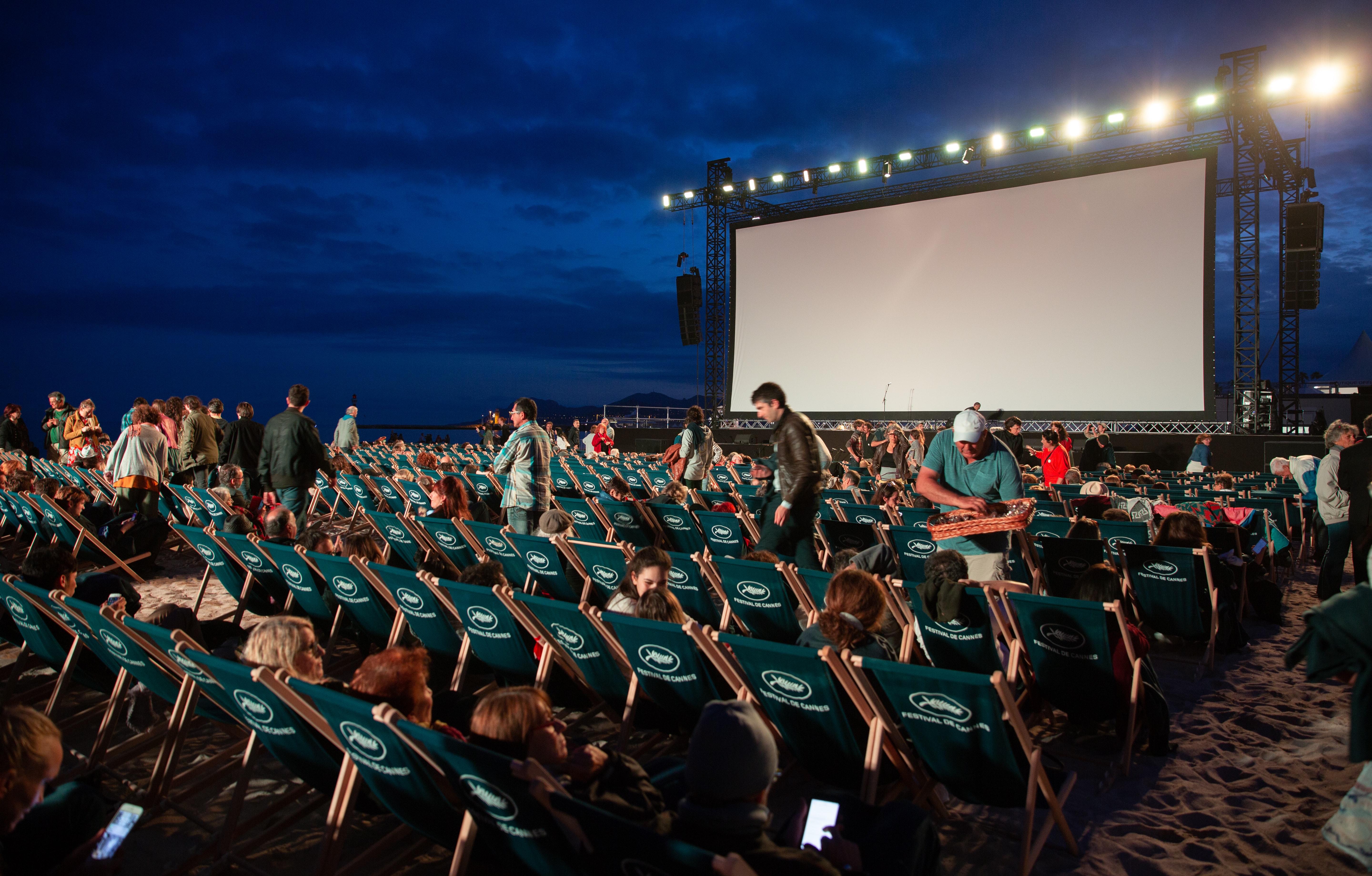 people watching movies in an open air set up